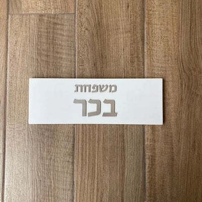 A concrete sign for a home in a personalized design, white in color with silver lettering  Name + Family Name / Door sign + Mezuzah case + nu