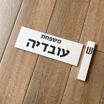 A white concrete house sign with black lettering - Family series 