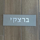 A design sign for a door made of clean concrete in gray with silver lettering - Israel series