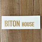 Personalized door sign made of clean white concrete with gold lettering - HOUSE series