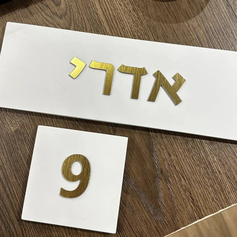 A handmade home sign made of clean white concrete with gold lettering - Israel Series 