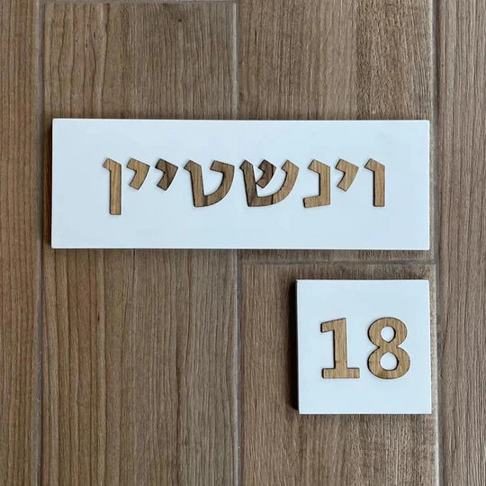 Designed sign for a white concrete entrance door with wooden lettering - Israel series 