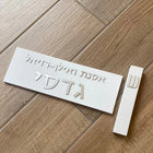 A designed sign for the entrance to a house with names made of white concrete with silver lettering - Israel series