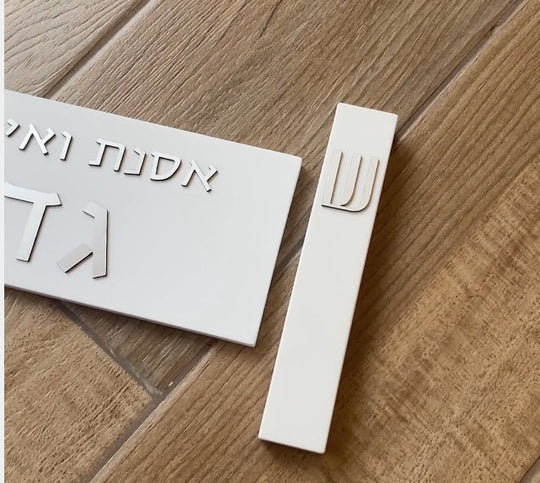 A designed sign for the entrance to a house with names made of white concrete with silver lettering - Israel series 