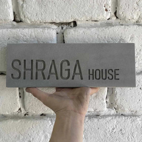 A designed sign for the entrance to a house with names made of natural concrete in gray with engraving - Concrete Chic series 
