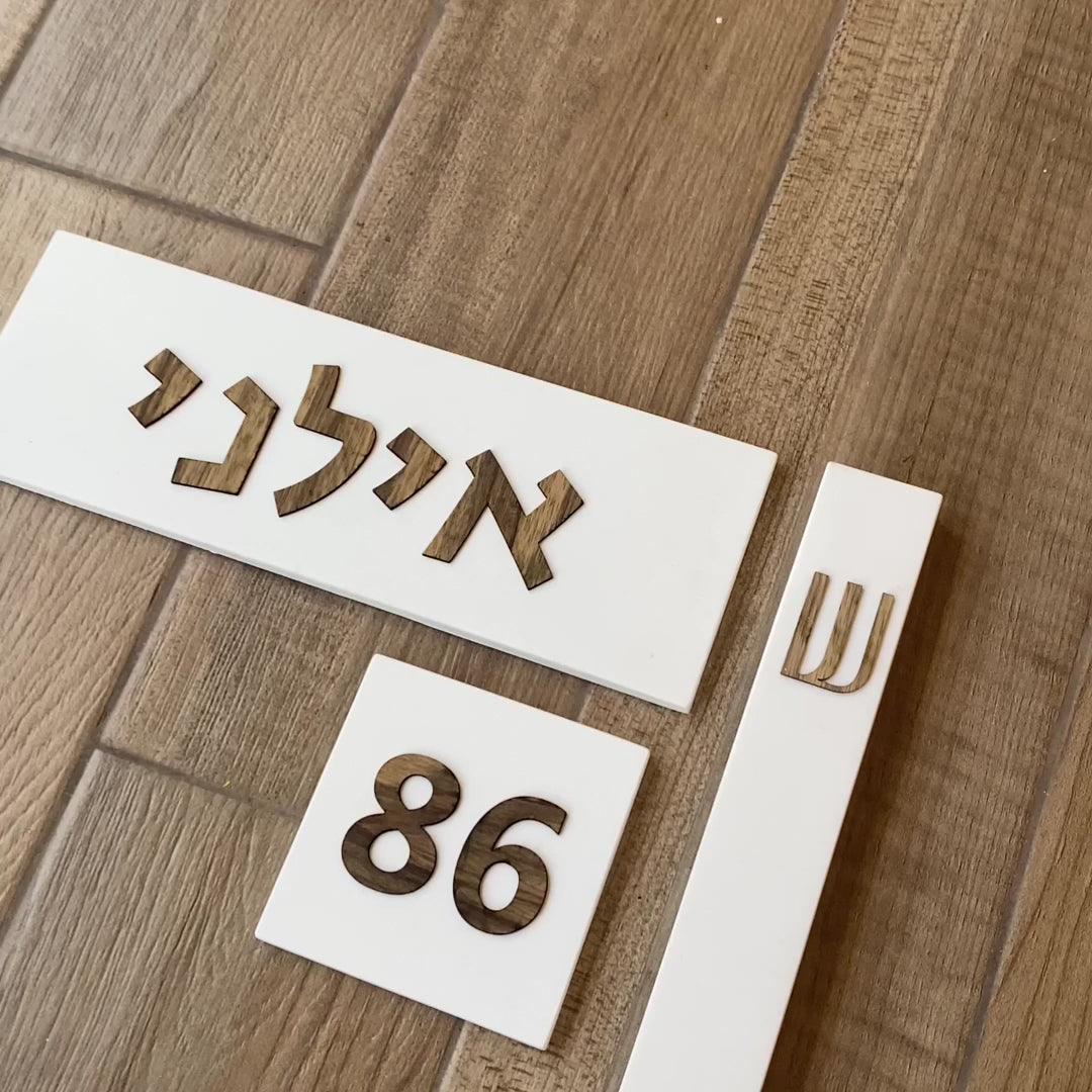Designed sign for a white concrete entrance door with wooden lettering - Israel series